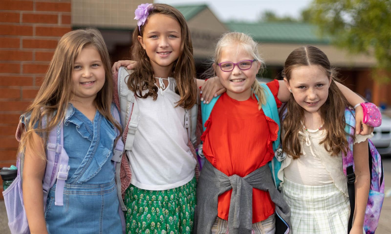 Four girls smile on the first day of school